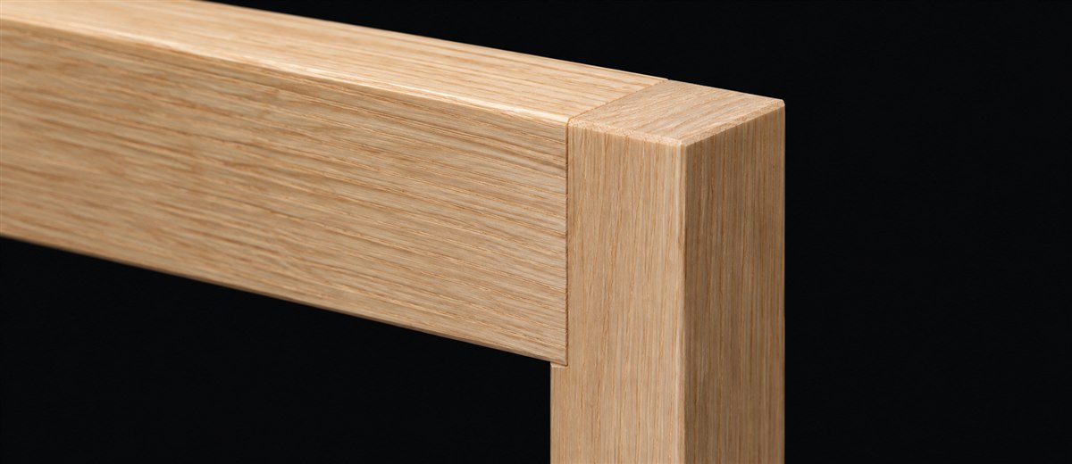 Pale pine rail meeting a square post in a clean right-angle joint